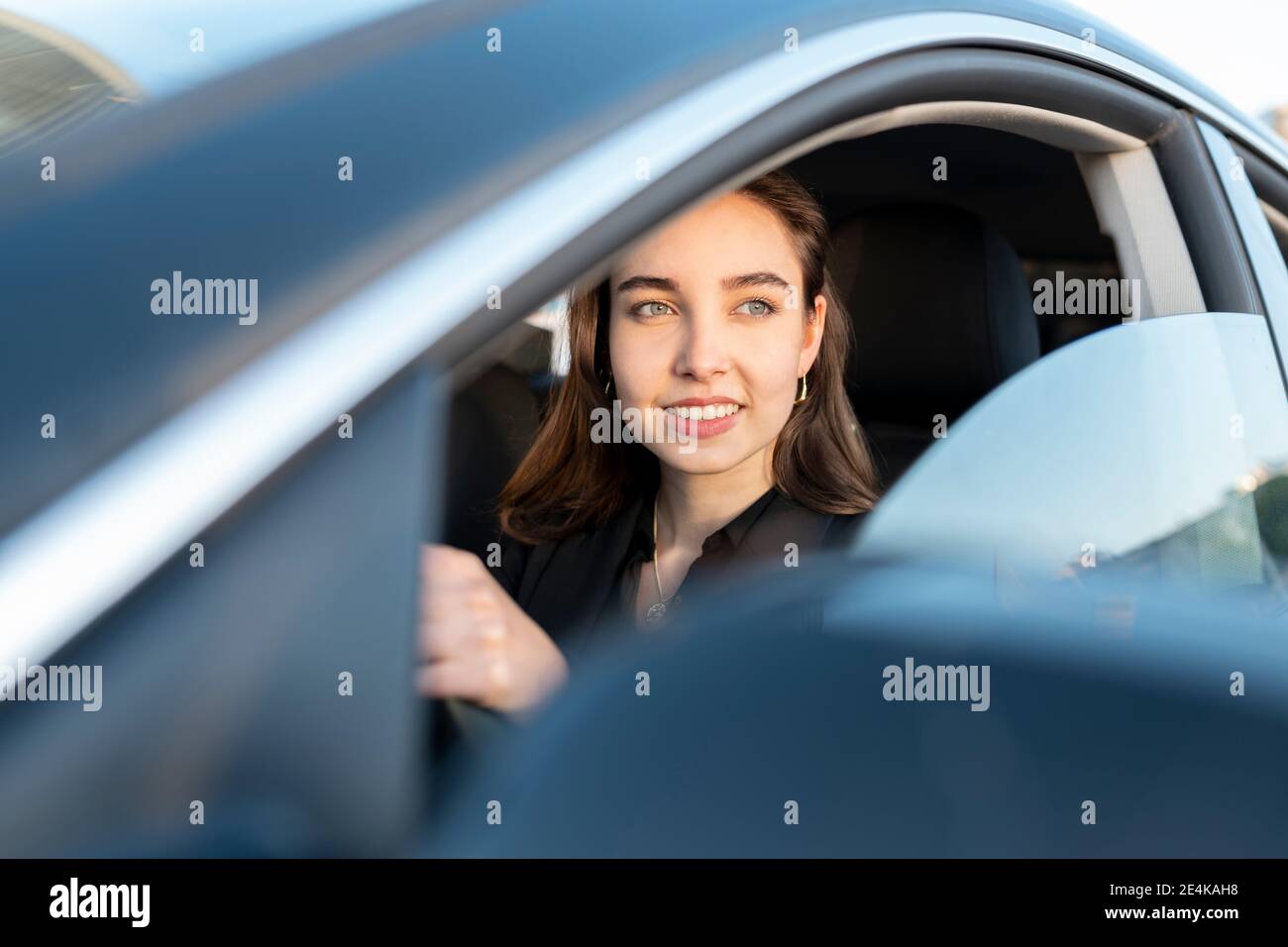 Femme d'affaires souriant en voiture Banque D'Images