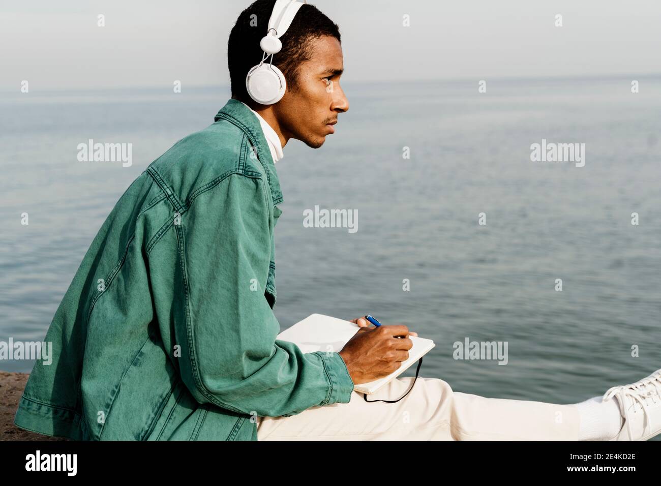 Homme attentionné avec un livre qui donne sur la mer Banque D'Images