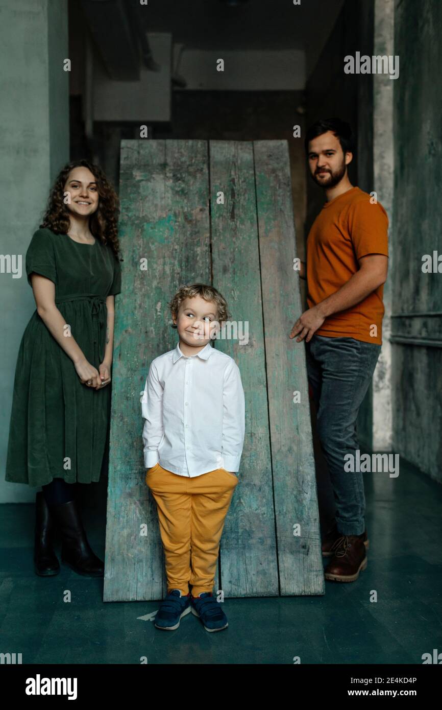 Garçon avec les mains dans les poches debout par les parents Banque D'Images