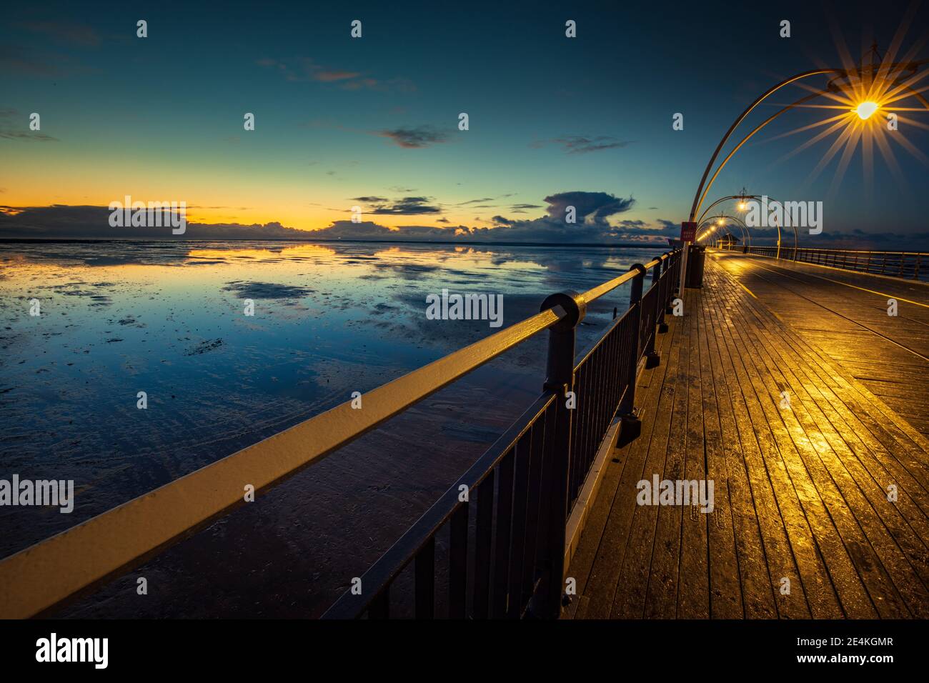 Après le coucher du soleil sur la jetée de Southport en regardant les réflexions dans l'eau fixe Banque D'Images