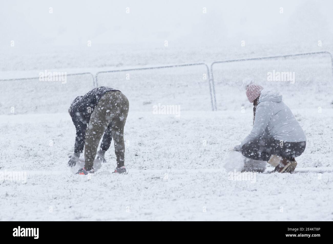 Londres, Royaume-Uni. 24 janvier 2021. Un homme et une femme roulent de grosses boules de neige au parc Gunnersbury. Crédit : Liam Asman/Alay Live News Banque D'Images