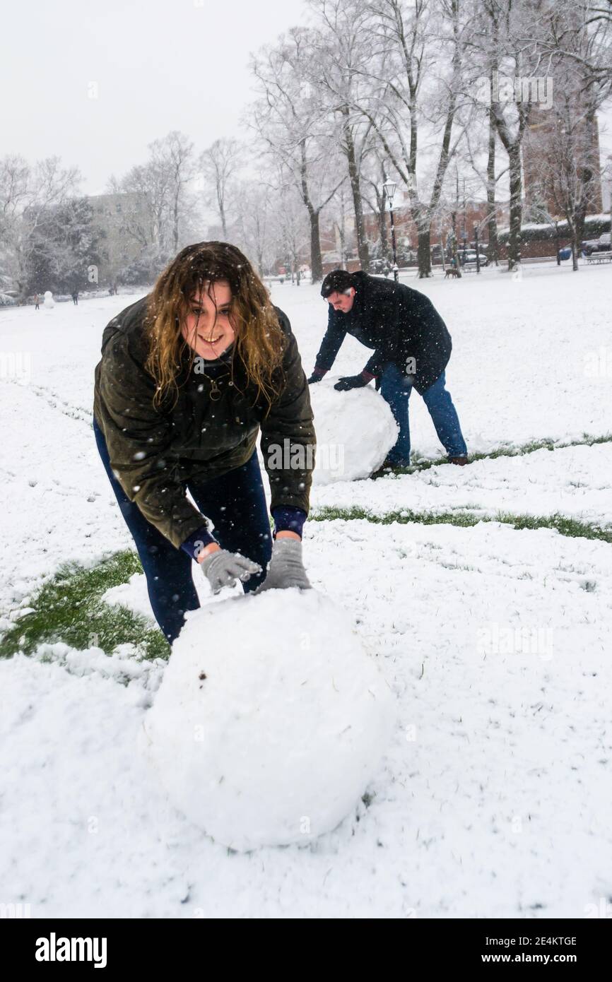 Leamington Spa, Warwickshire, Royaume-Uni: 24 janvier 2021: Les fêtards se réchauffent pour construire des bonhommes de neige dans le parc Victoria, comme un grand groupe de neige peint le pays blanc le dimanche matin. Credit: Ryan Underwood / Alamy Live News Banque D'Images