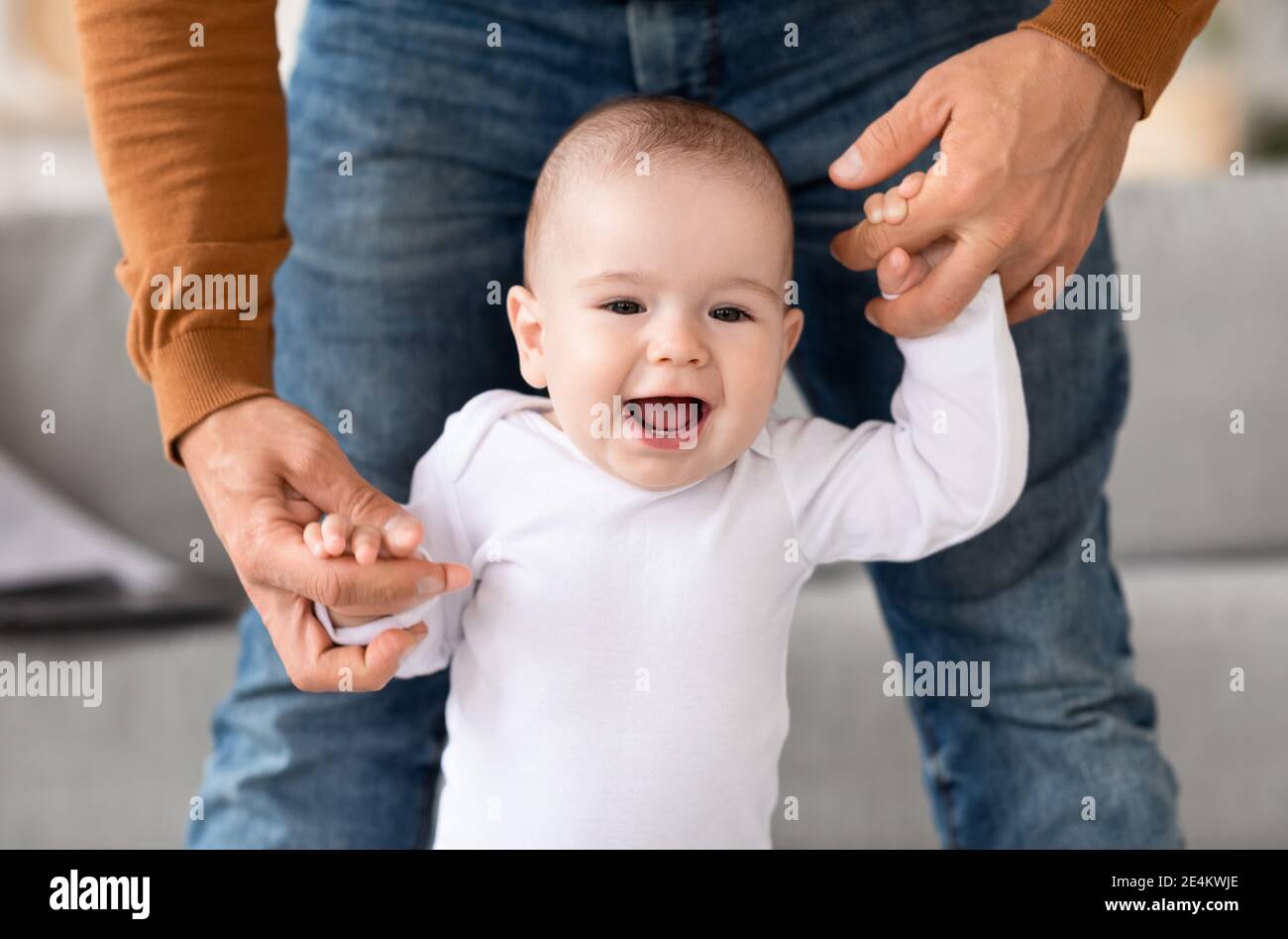 Papa Aider Son Bebe A Marcher Faire Les Premiers Pas A La Maison Photo Stock Alamy