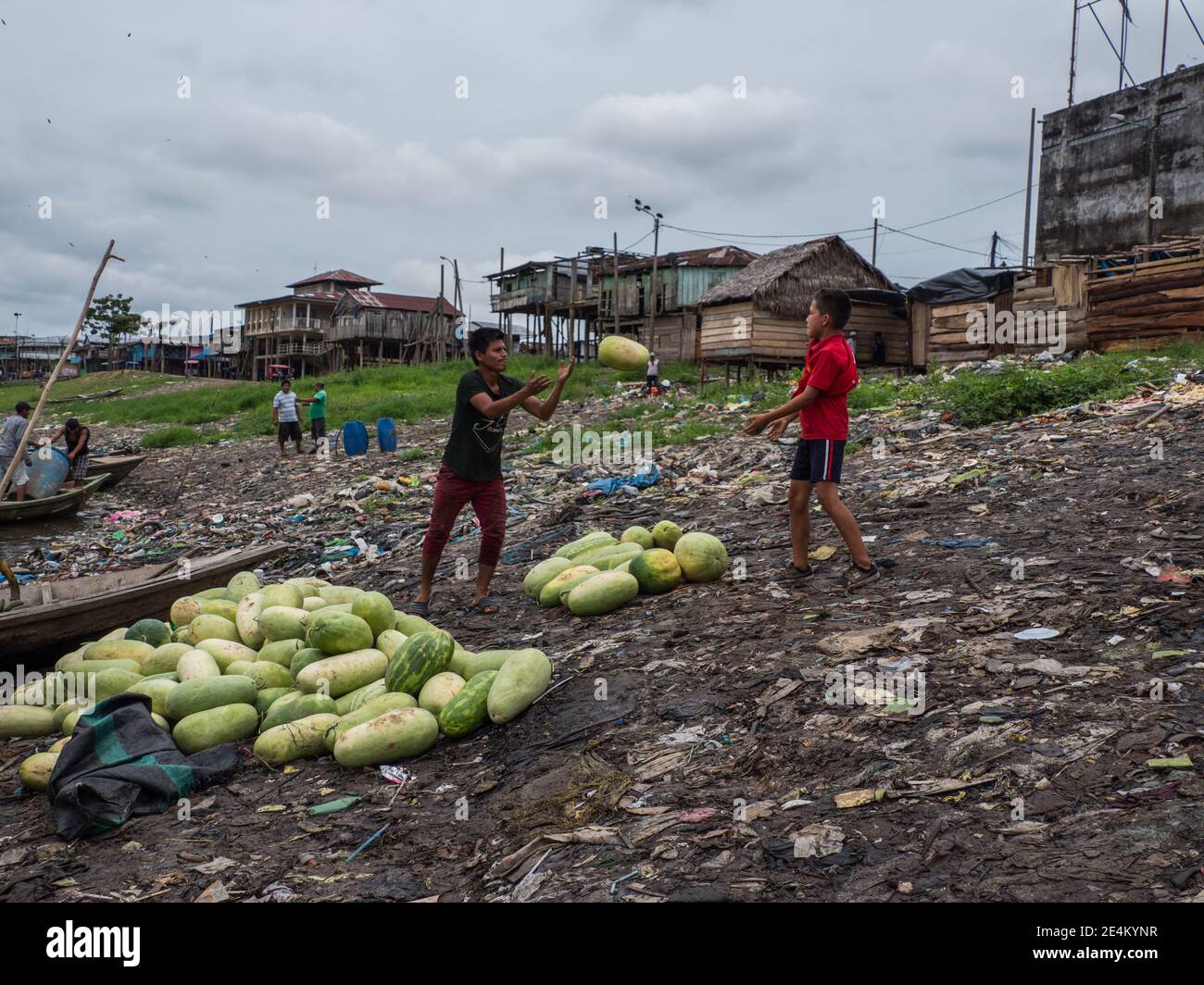 Iquitos, Pérou - septembre 2019 : les hommes déplacent les fruits d'un bateau. On peut observer une pollution énorme en arrière-plan sur les rives de la rivière Itaya. Bas A Banque D'Images