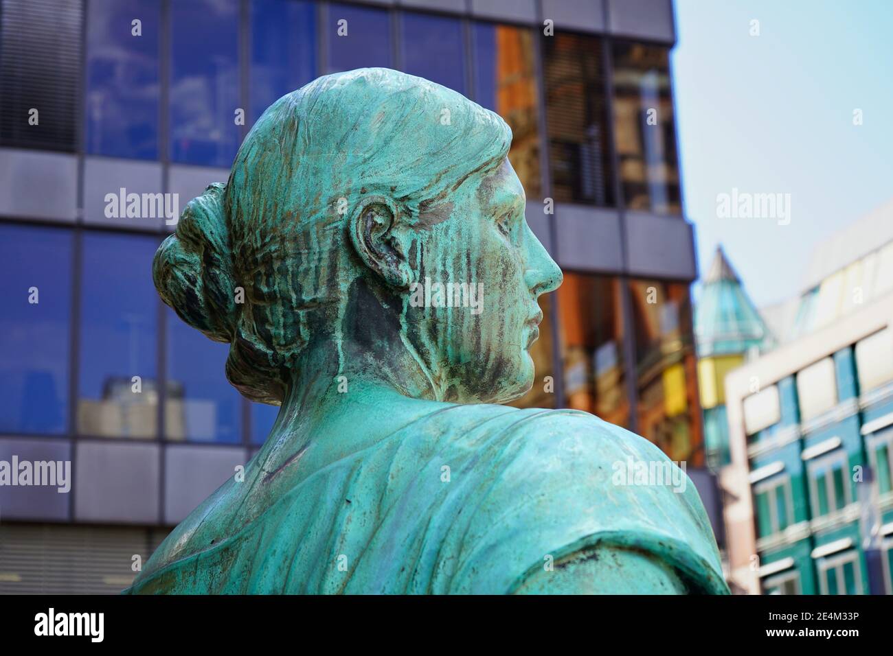 Ancienne sculpture en bronze d'une femme, partie allégorique du monument Bismarck dans le centre-ville de Düsseldorf, dévoilée en 1899. Bâtiments modernes en arrière-plan. Banque D'Images