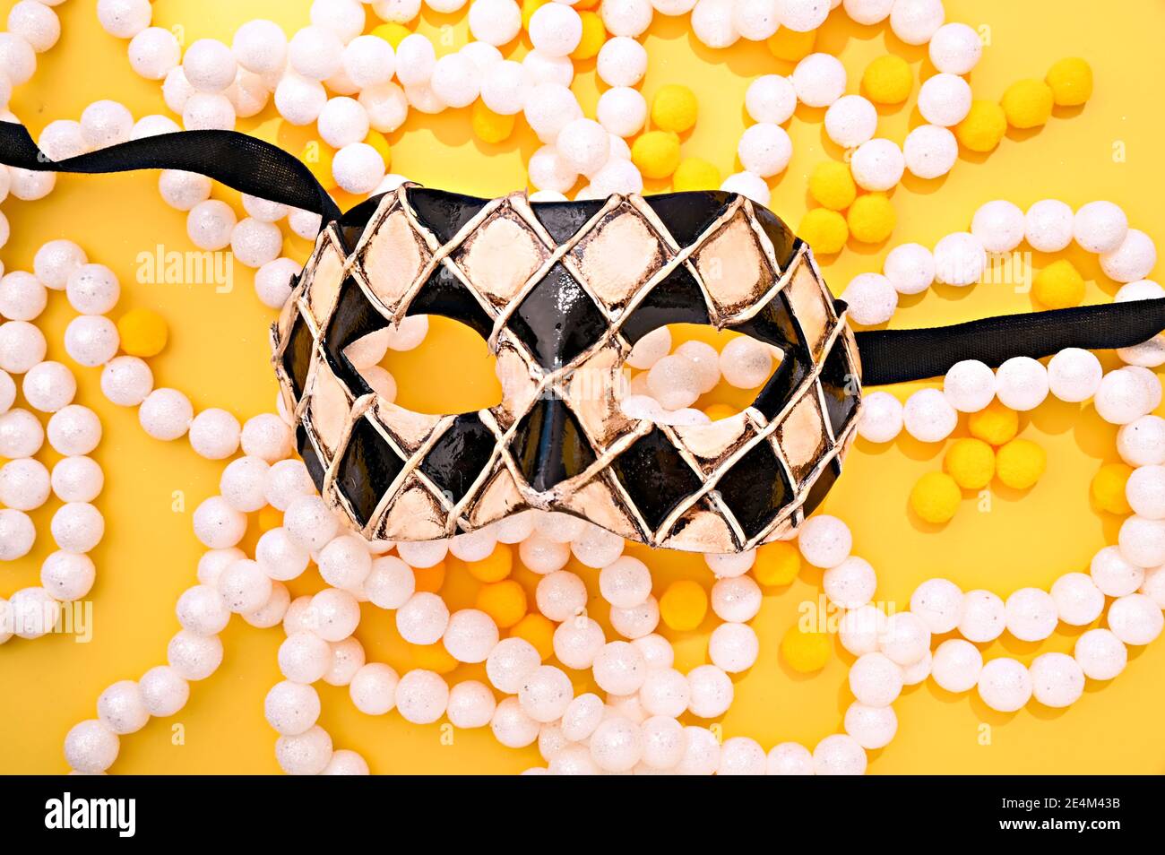 Masque de carnaval et guirlande festive sur fond lumineux. Image pour une couverture ou une affiche. Le concept de carnaval de Venise en italie. Photo de haute qualité Banque D'Images