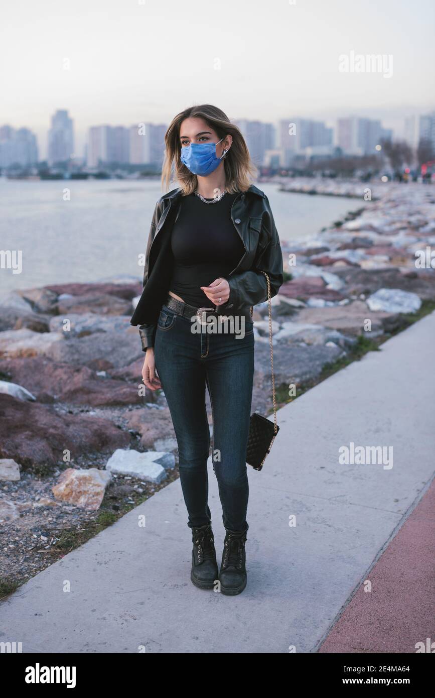 Portrait d'une adolescente avec un masque médical dans la rue. Banque D'Images
