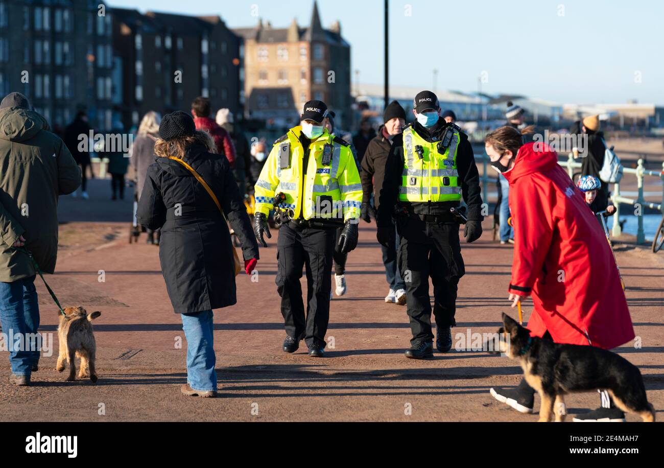 Portobello, Écosse, Royaume-Uni. 24 janvier 2021. Grand nombre de membres du public à Portobello Beach et promenade le dimanche après-midi ensoleillé pendant l'isolement. Alors que la plupart des gens ont observé des groupes sociaux distanciants de personnes se sont formés dans certains des cafés offrant des plats à emporter et des boissons. Les patrouilles de police ont parlé au public assis et en groupes dans les cafés pour leur demander de continuer. Iain Masterton/Alay Live News Banque D'Images