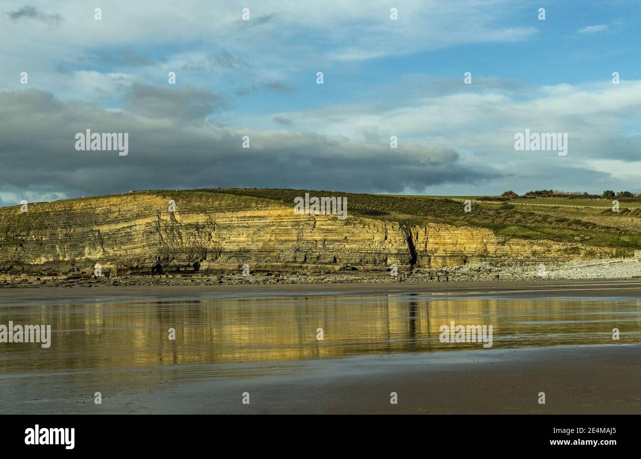 Baie de Dunraven avec sable humide et reflets de la falaise voisine, Glamourgan Heritage Coast, pays de Galles du Sud. Banque D'Images