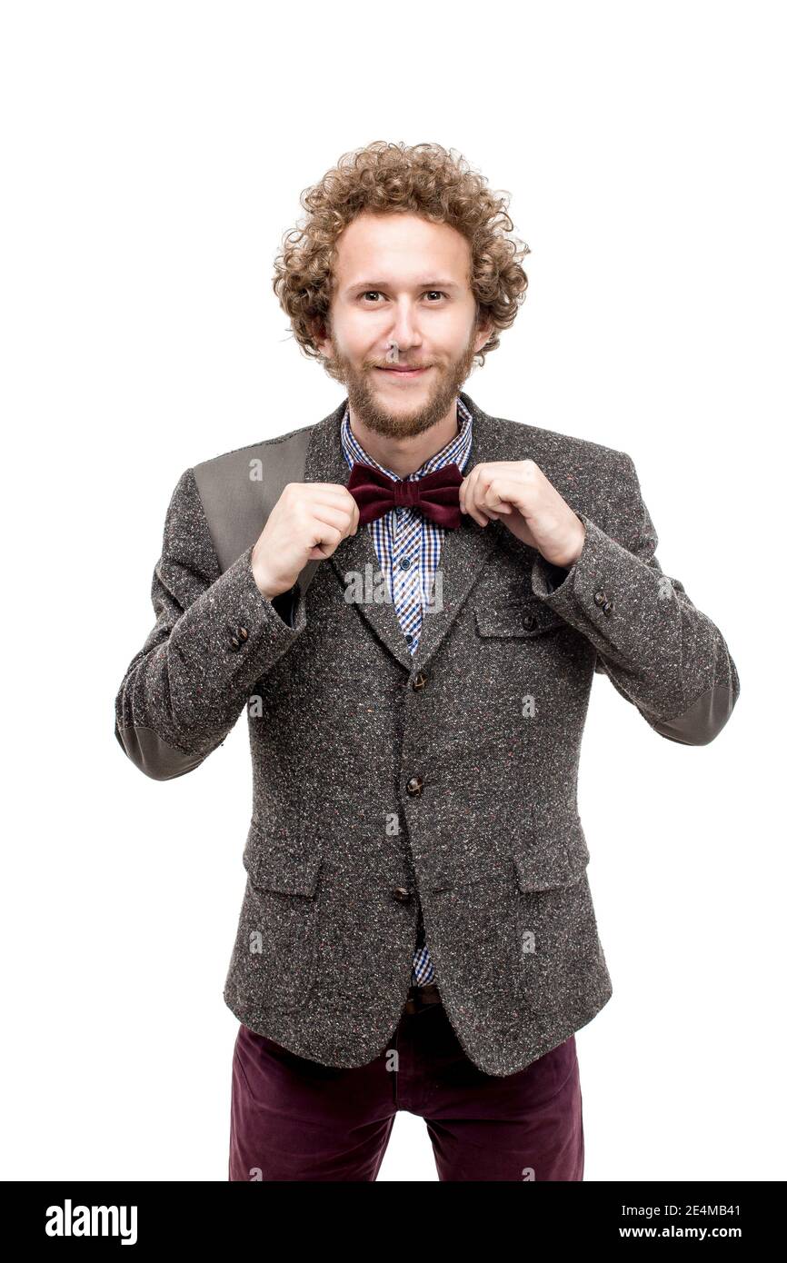 Portrait d'un homme d'affaires aux cheveux bouclés avec succès tenant un nœud papillon et souriant appareil photo Banque D'Images