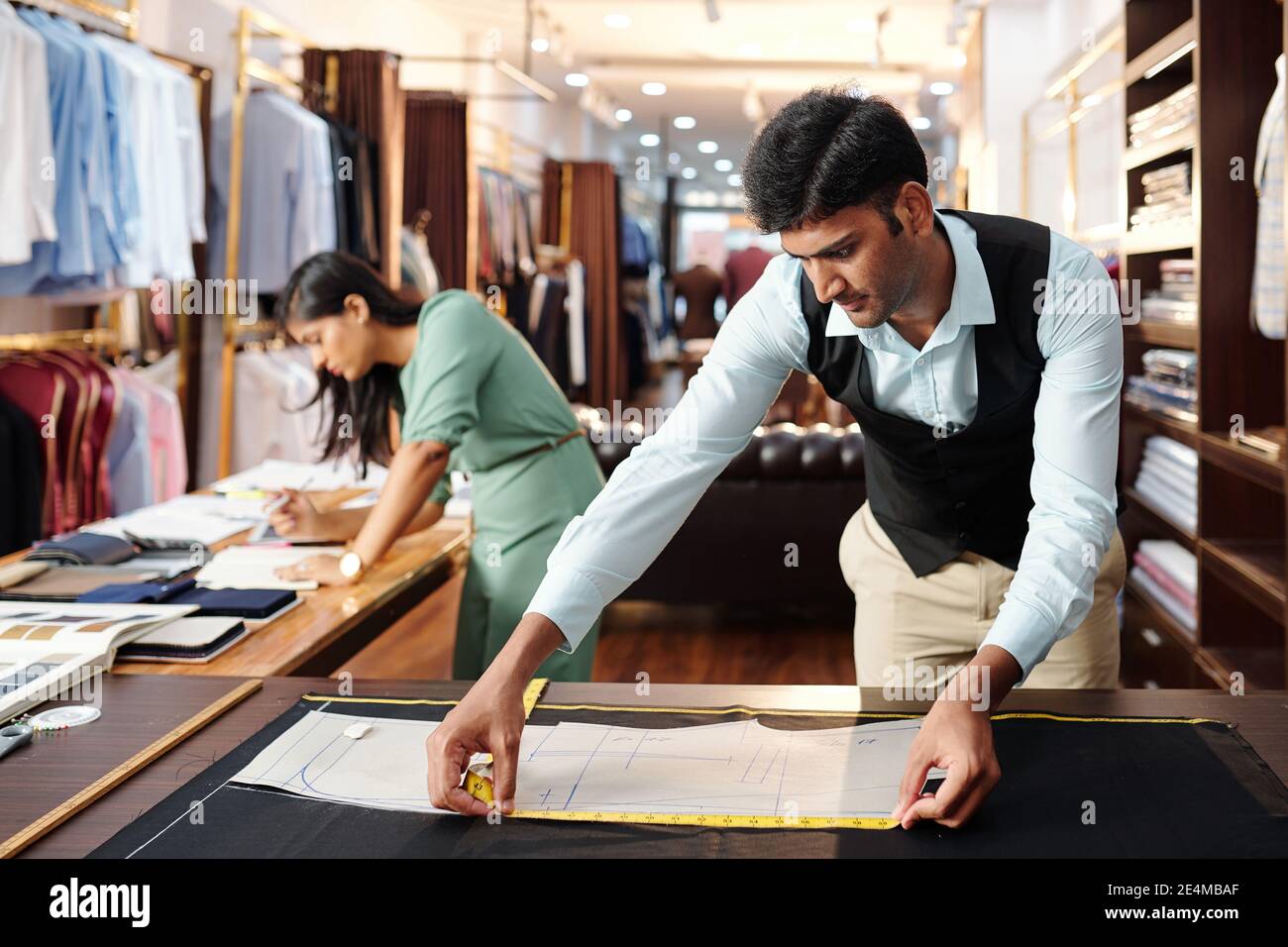 Jeune indien concentré mesure de couture modèle de veste pour client Banque D'Images