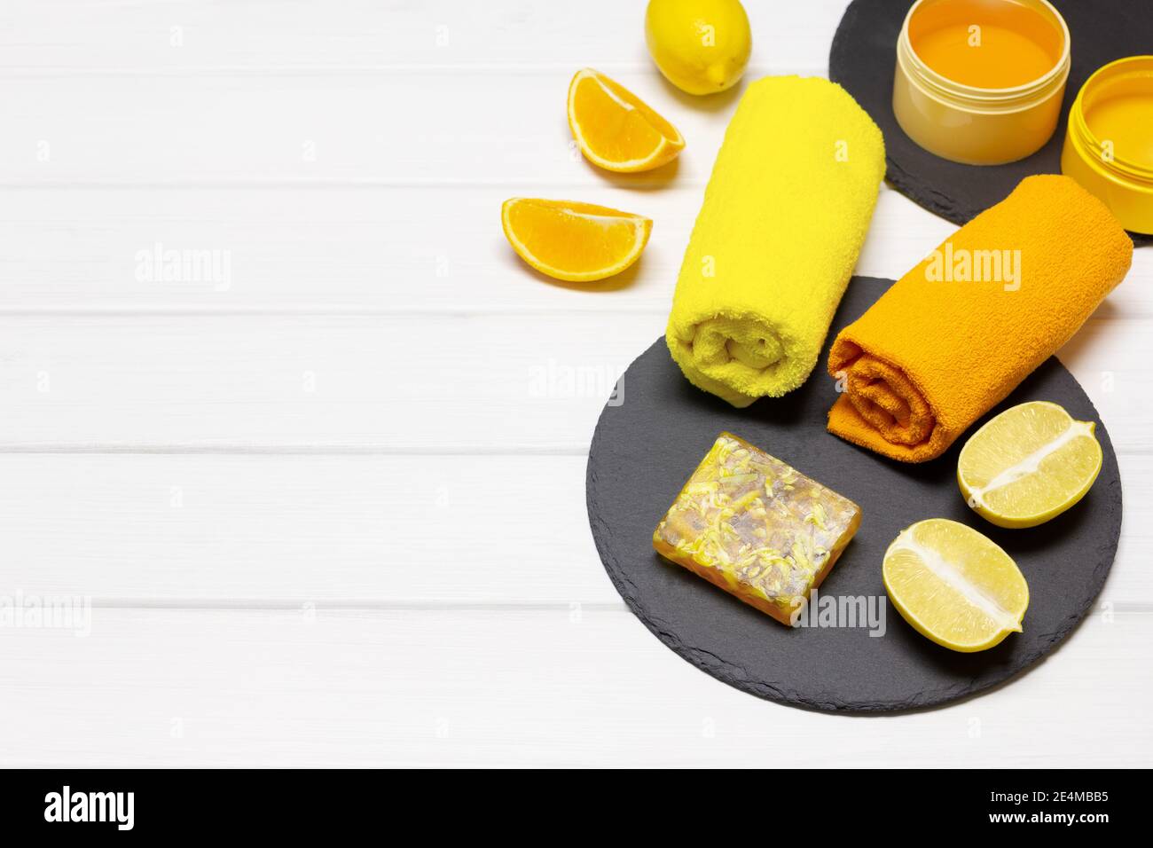 Concept de cosmétiques naturels de soins de la peau biologiques. Savon d'agrumes maison avec des citrons, des oranges et des serviettes sur une table en bois blanc. Copier l'espace Banque D'Images