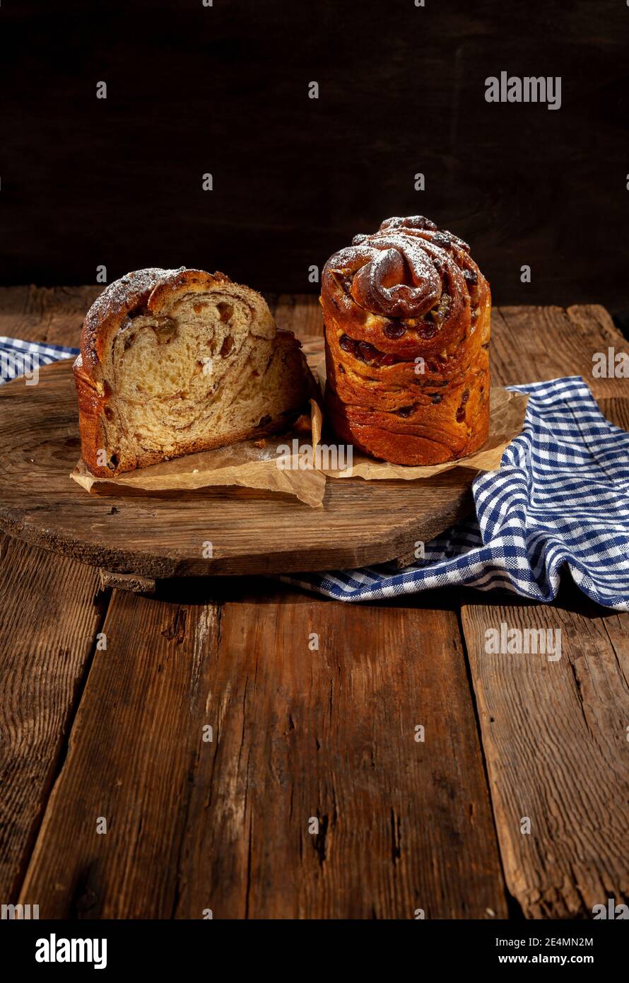 Kraffin gâteau de Pâques. Kraffins aux raisins secs, fruits confits et graines de pavot, arrosés de sucre en poudre. Gros plan de gâteau maison. Brut. Banque D'Images