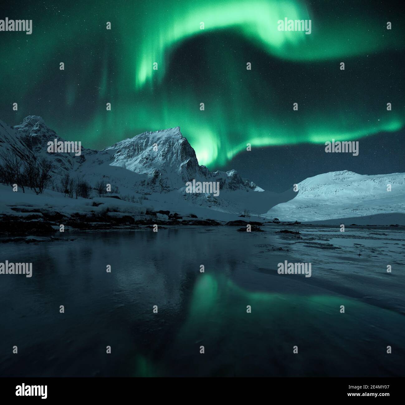 Lumières du Nord vives sur des montagnes épiques escarpées et enneigées, Lofoten, Norvège Banque D'Images