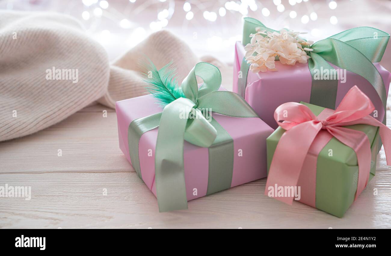Cadeaux dans un magnifique paquet et un pull doux sur un fond clair avec  une guirlande brûlante Photo Stock - Alamy