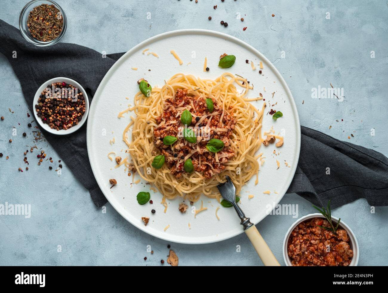 Pâtes bolognaises, fromage, parmesan et basilic sur fond gris. Banque D'Images