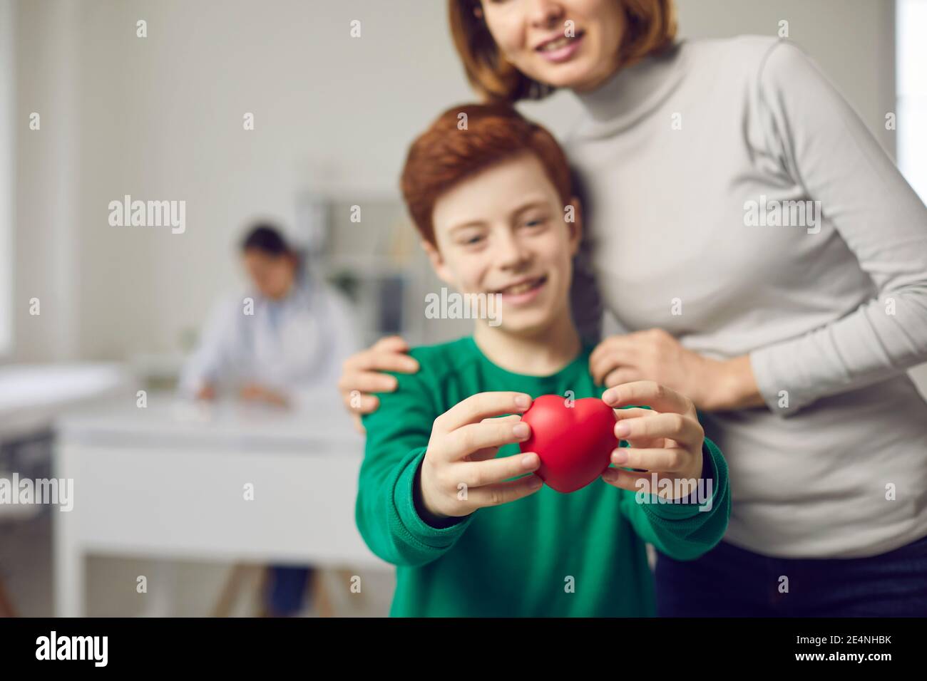 Joyeux garçon avec maman tenant le coeur rouge comme symbole de bonne santé et don d'organes Banque D'Images