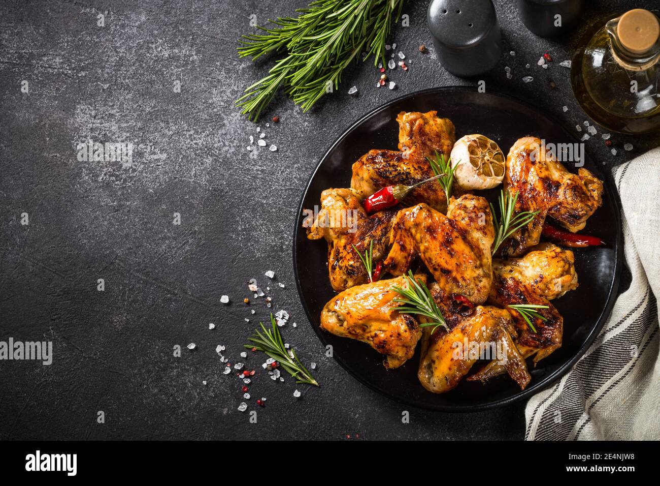 Ailes de poulet grillées aux épices à table noire. Banque D'Images