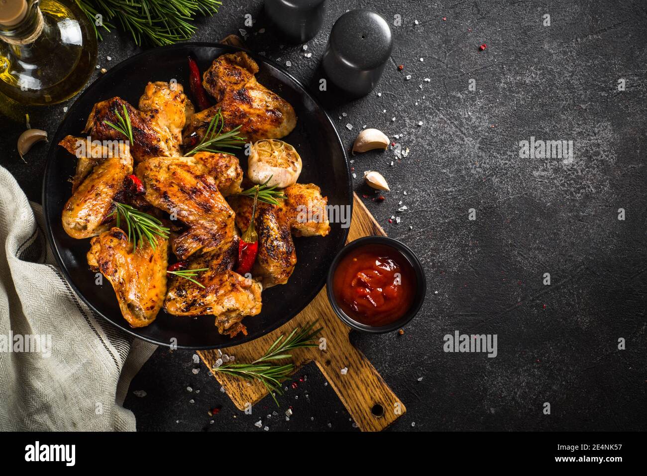 Ailes de poulet grillées aux épices à table noire. Banque D'Images