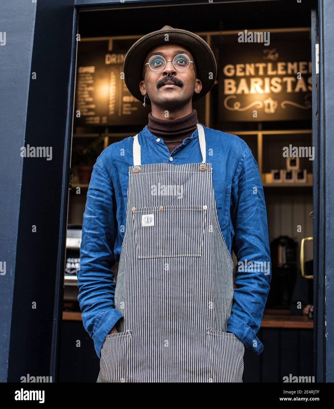 Un propriétaire de café Barista masculin portant un tablier à l'extérieur du café-restaurant, début d'affaires de nourriture et de boissons. Banque D'Images