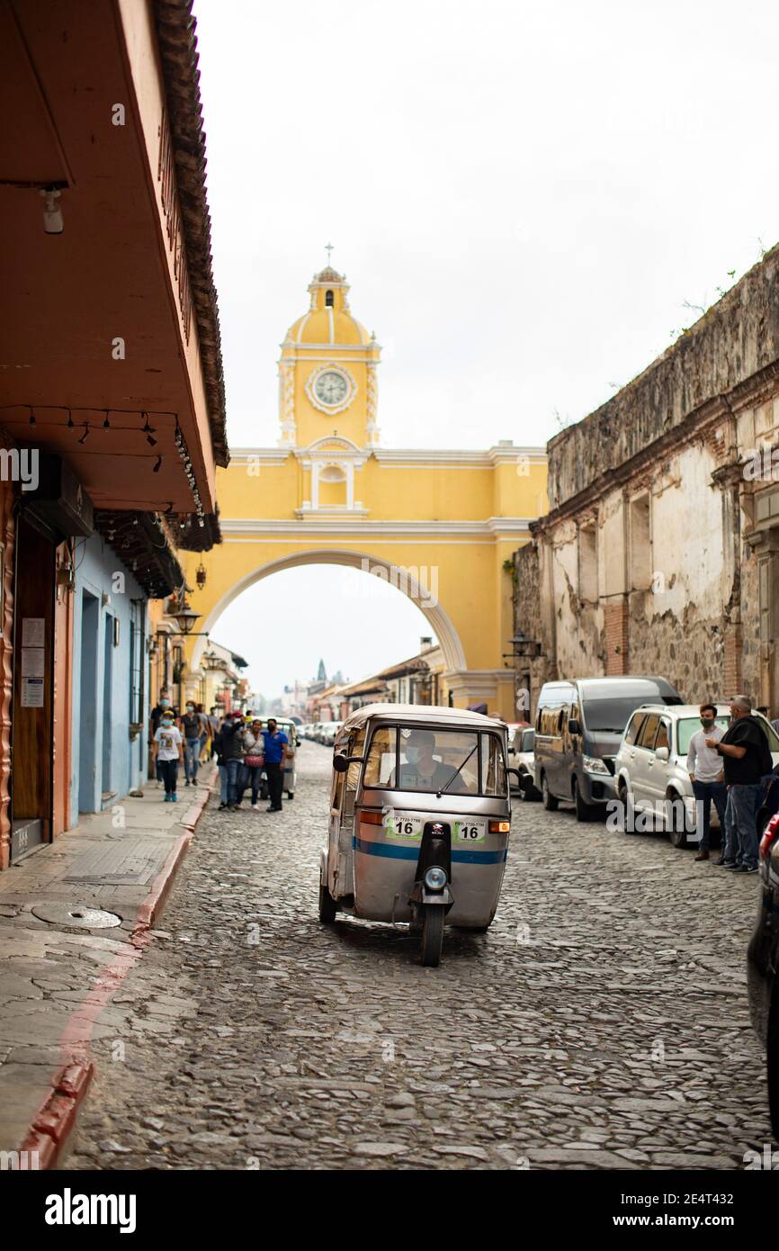 Véhicule de transport en commun tuk-tuk traversant l'arche de Santa Catalina à Antigua, Guatemala, Amérique centrale Banque D'Images