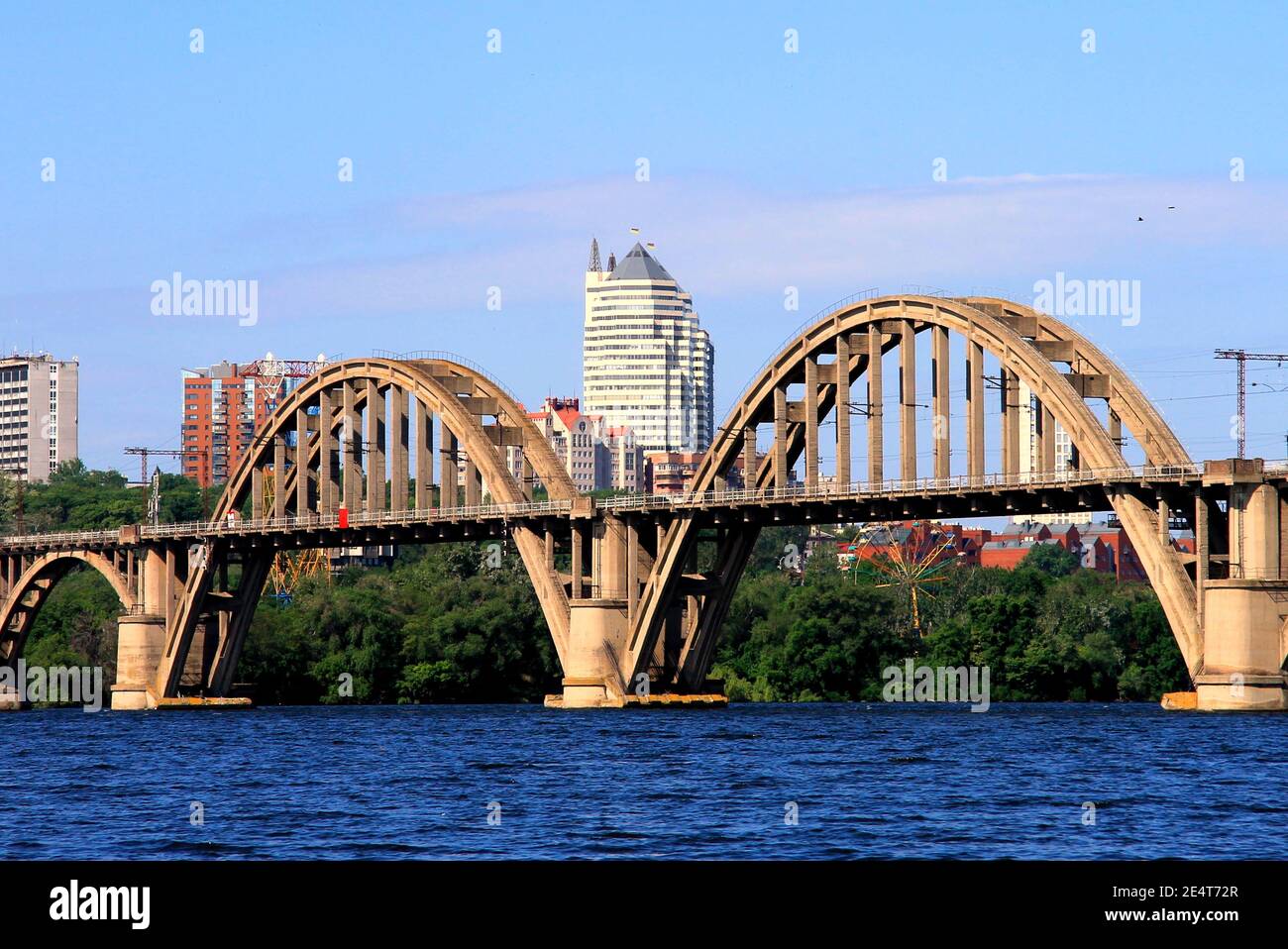 Pont ferroviaire voûté sur la rivière, gratte-ciel, tours. Printemps, vue d'été de la rivière Dnipro et de la ville Dnepropetrovsk, Dnepr, Ukraine. Banque D'Images