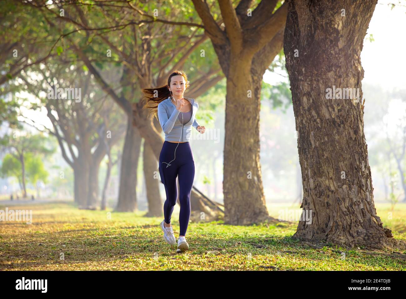 belle jeune femme qui court dans le parc le matin Banque D'Images