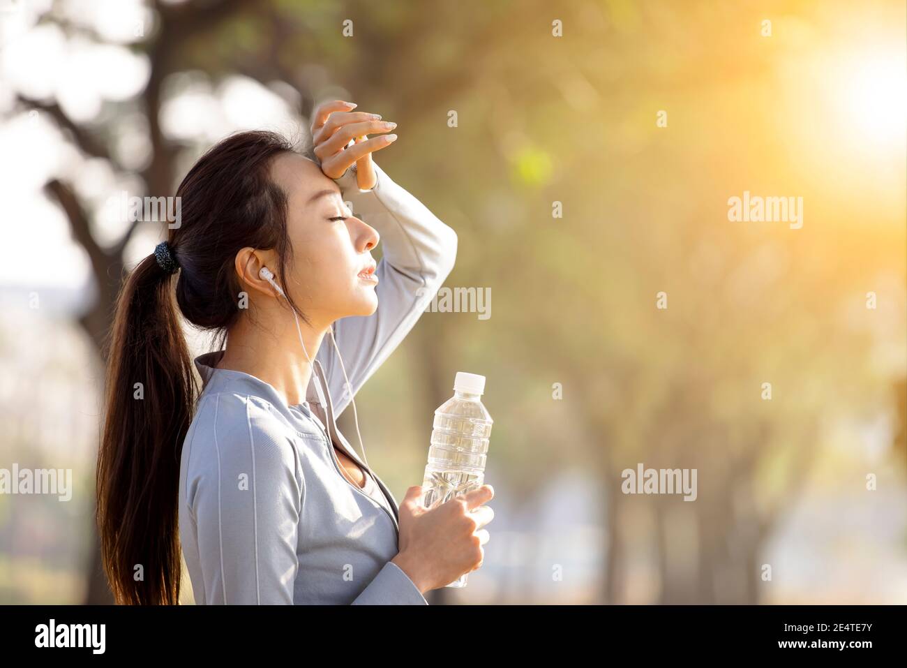 Jeune femme à boire de l'eau après le jogging Banque D'Images