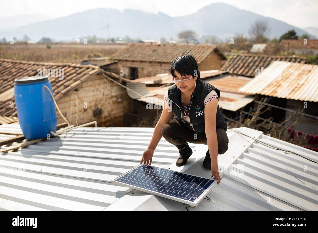 Un technicien de la société locale d'électricité à but non lucratif installe un nouveau système d'éclairage solaire dans une maison à Cantel, au Guatemala. Banque D'Images