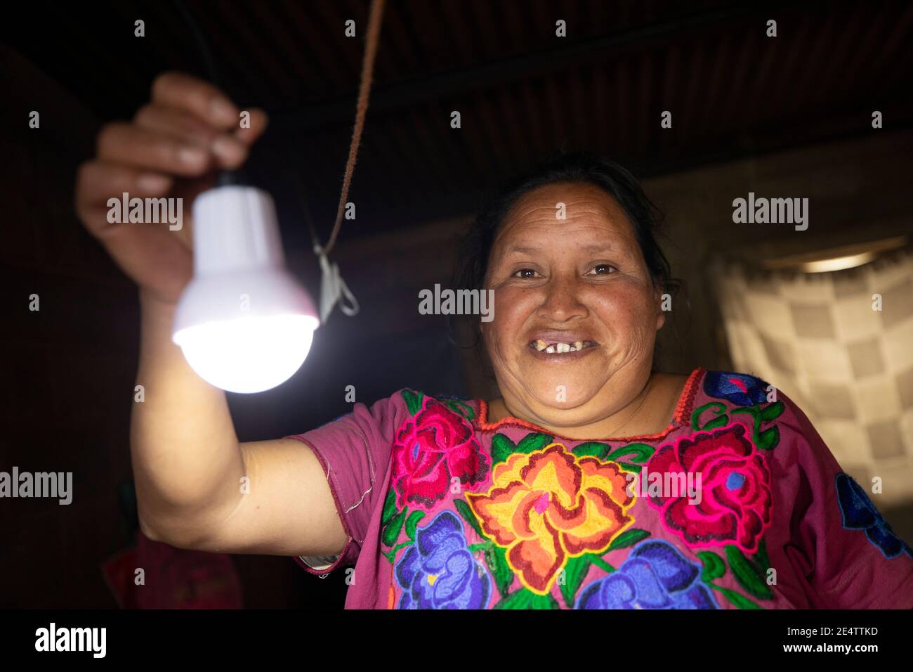 Une femme allume ses lumières solaires pour la première fois chez elle à Cantel, au Guatemala, en Amérique centrale. Banque D'Images