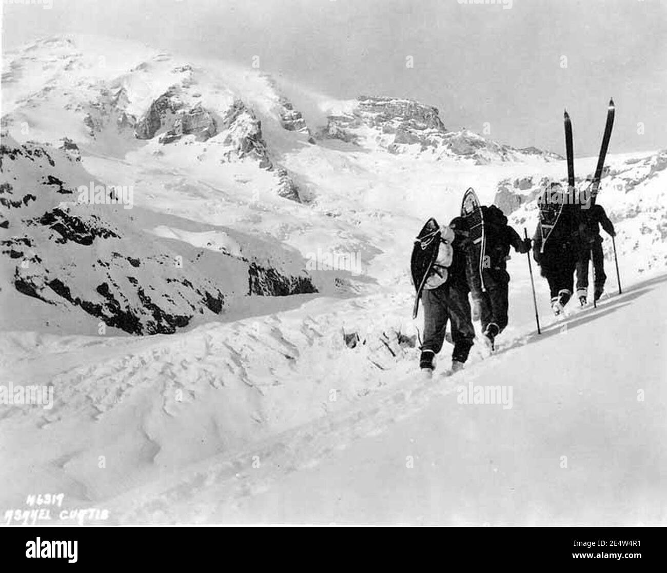 Les membres du club de la SOYP qui font de la randonnée en pente avec des raquettes et des skiis, parc national du Mont Rainier, 1925 (WASTATE, 1297). Banque D'Images
