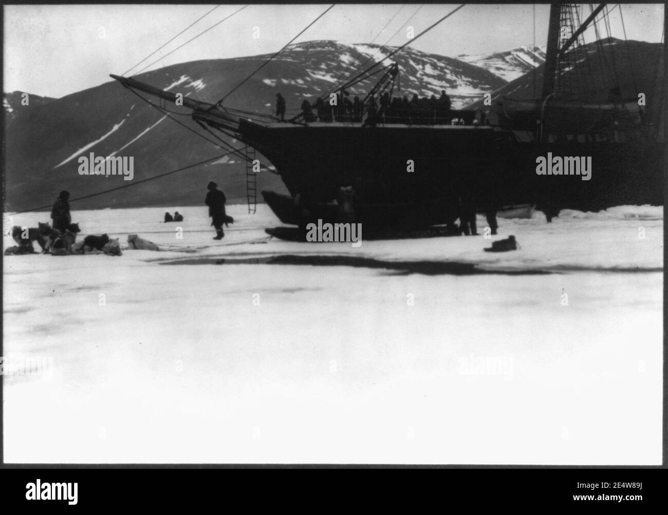 Des hommes, des chiens de traîneau et de petits bateaux sur la glace à bord du navire NEPTUNE; expédition dans l'Arctique. 1908-12 Banque D'Images