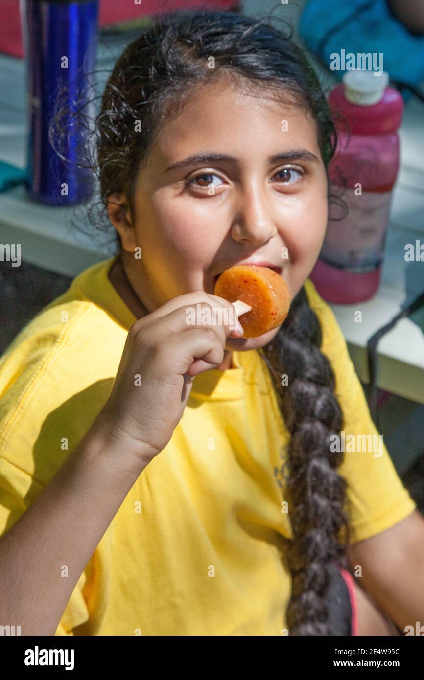 Une jeune fille mangeant une popsicle pendant un été chaud jour Banque D'Images