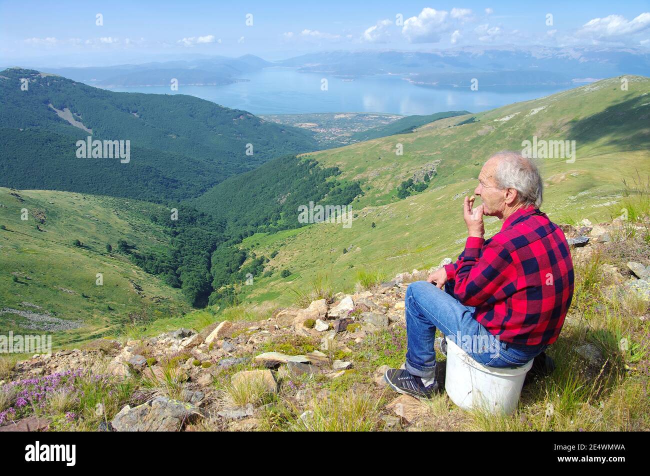 Bitola, République de Macédoine - 24 juillet 2011 : un homme âgé sur la ridgeline du parc national de Pelister fume en s'asseyant devant une terre idyllique Banque D'Images