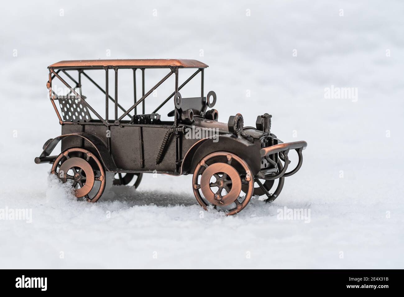 Modèle de bronze jouet voiture rétro se tient sur la neige blanche Banque D'Images