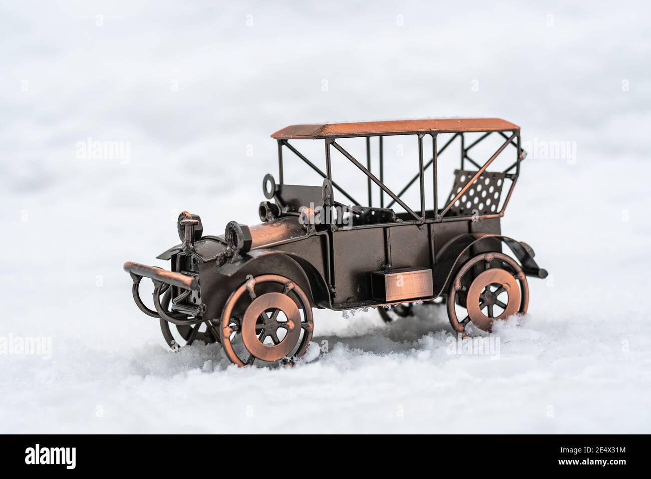 Modèle de bronze jouet voiture rétro se tient sur la neige blanche Banque D'Images