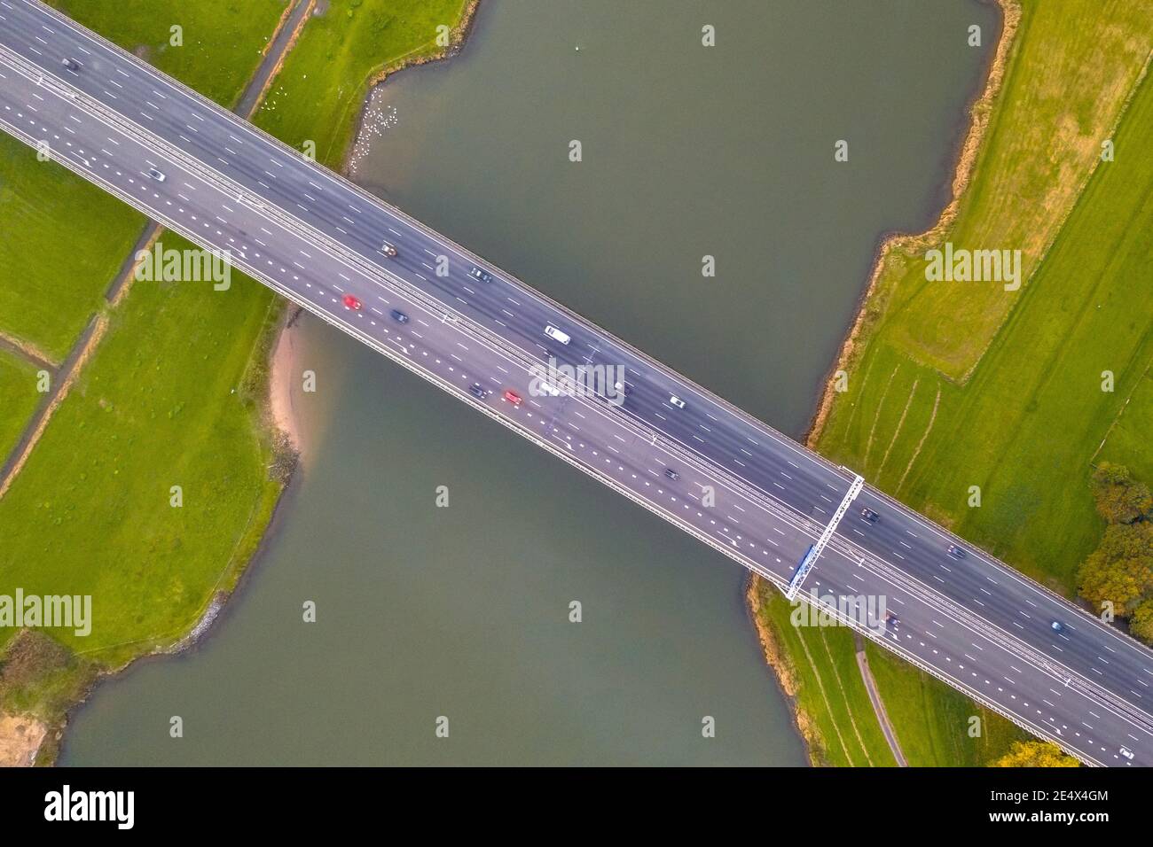 Vue aérienne de dessus en bas de l'immense rivière des basses terres IJssel avec pont de l'autoroute à travers le paysage agricole. Zwolle, province d'Overijssel, pays-Bas. Dr Banque D'Images