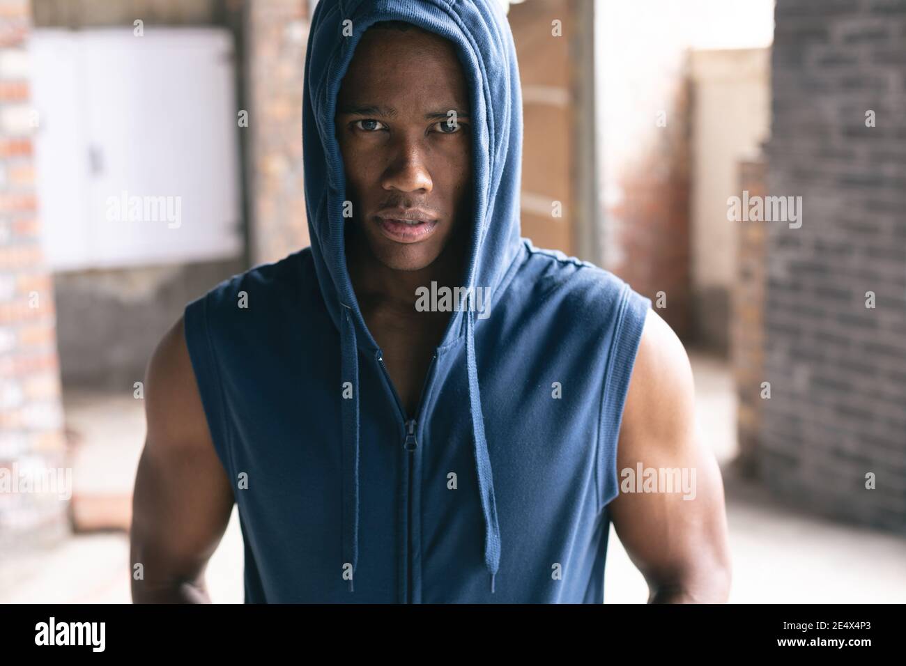 Portrait d'un homme afro-américain portant un sweat à capuche et regardant l'appareil photo dans un bâtiment urbain vide Banque D'Images