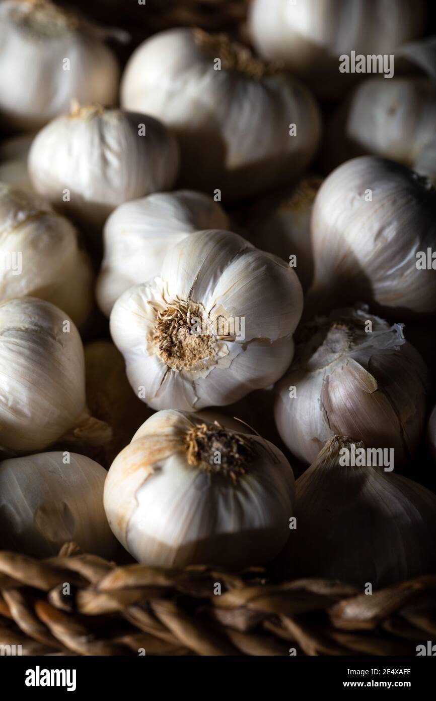 Bulbes à l'ail dans un panier sur fond de bois. Banque D'Images