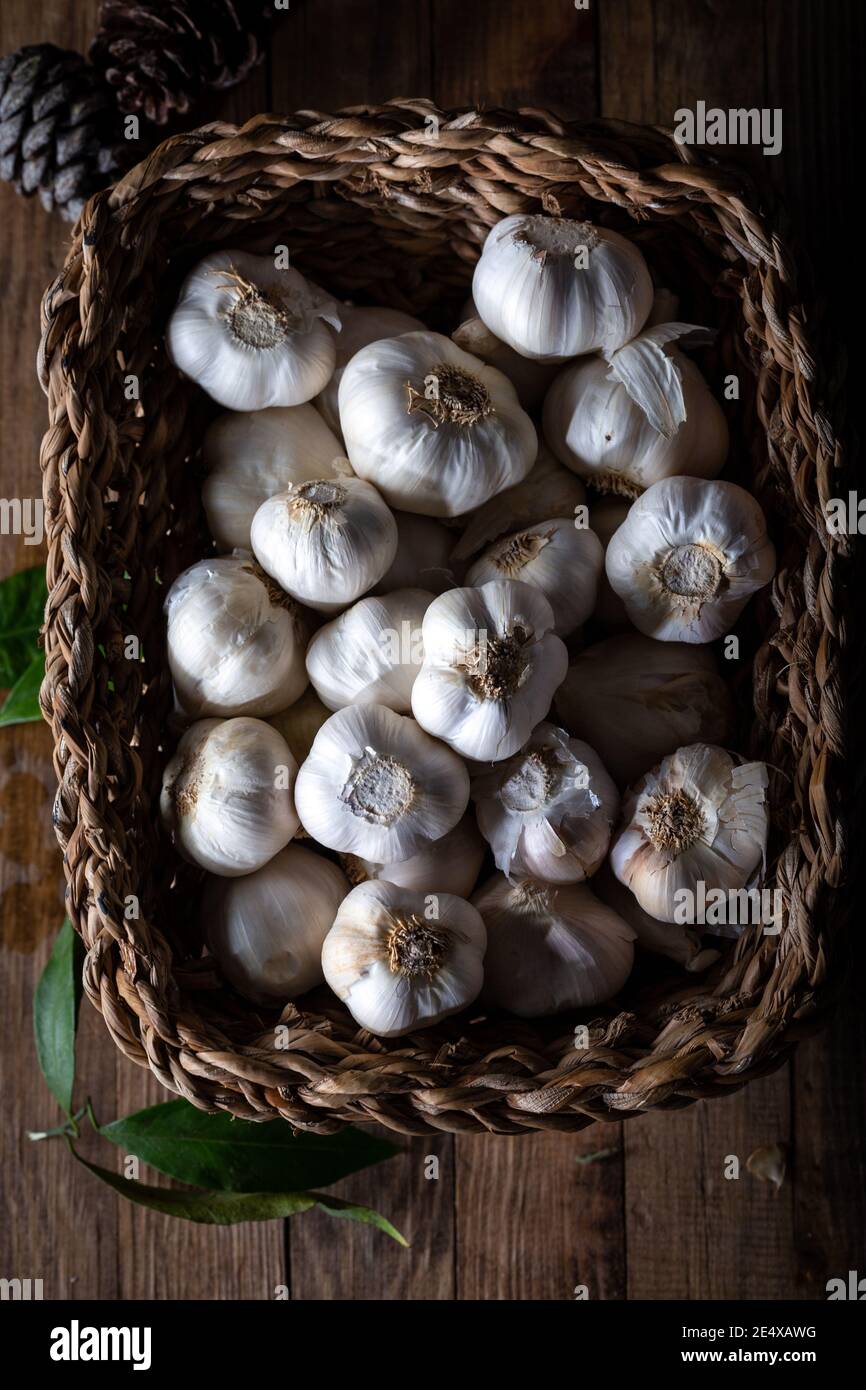 Bulbes à l'ail dans un panier sur fond de bois. Vue de dessus. Banque D'Images