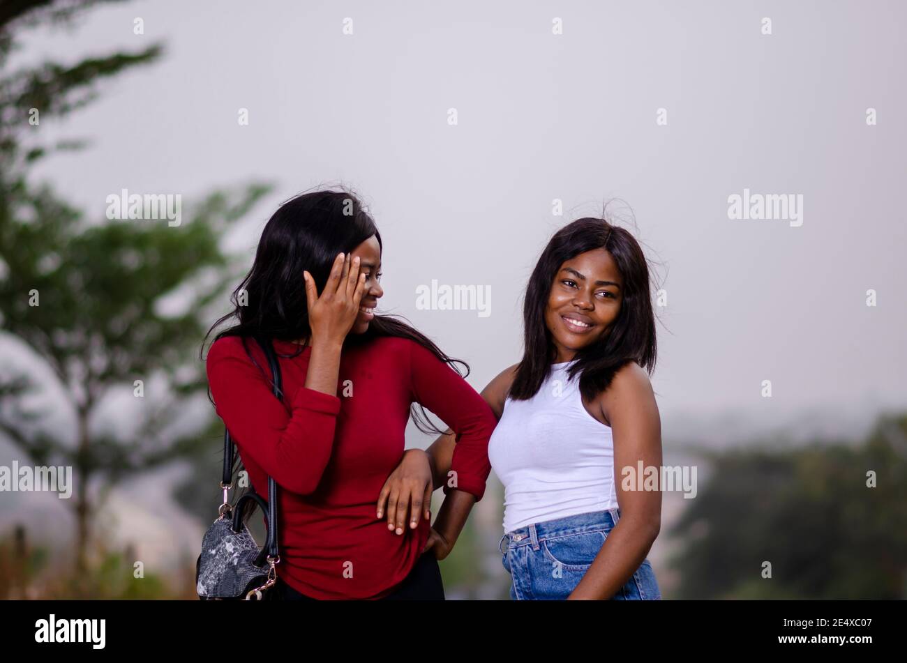 jeunes belles femmes africaines qui se promènent dans un jardin et avoir une discussion amicale Banque D'Images