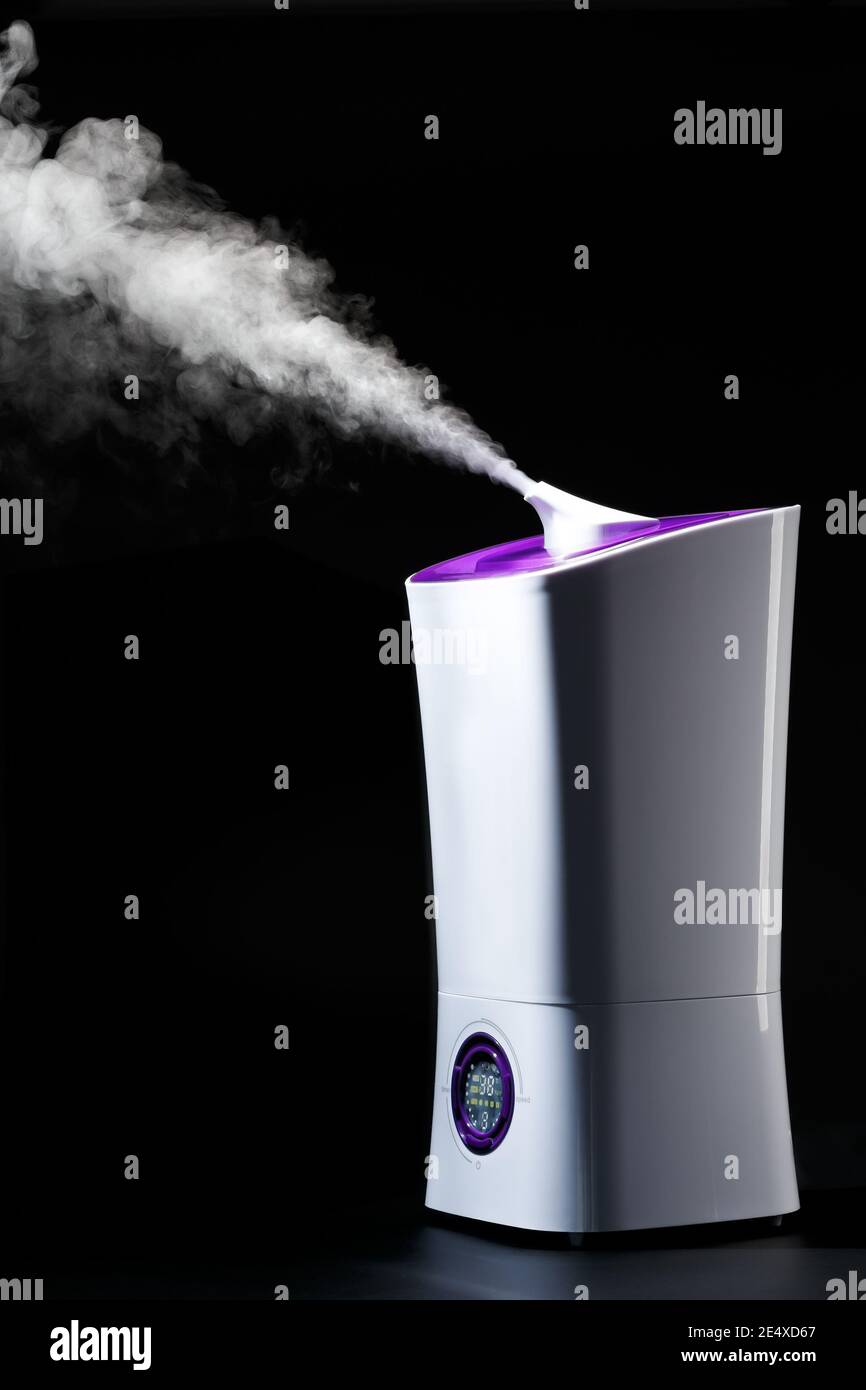 Humidificateur à ultrasons fonctionnant sur fond noir. Appareils électroménagers modernes pour la maison. Banque D'Images