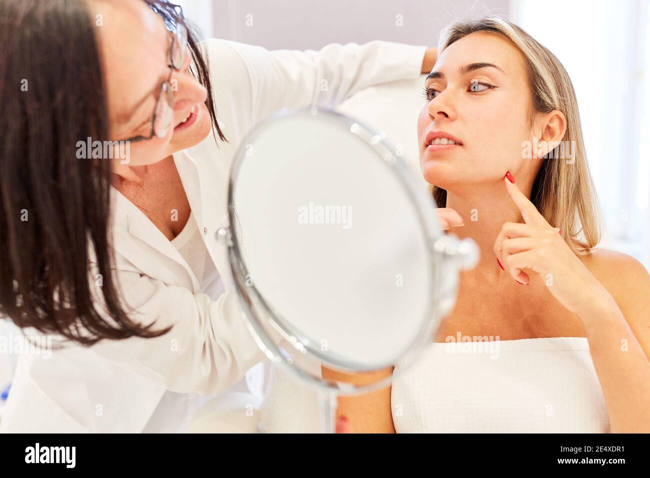 Médecin et patient donnant des conseils avant un facilift avec un dermatologue dans la clinique de beauté Banque D'Images