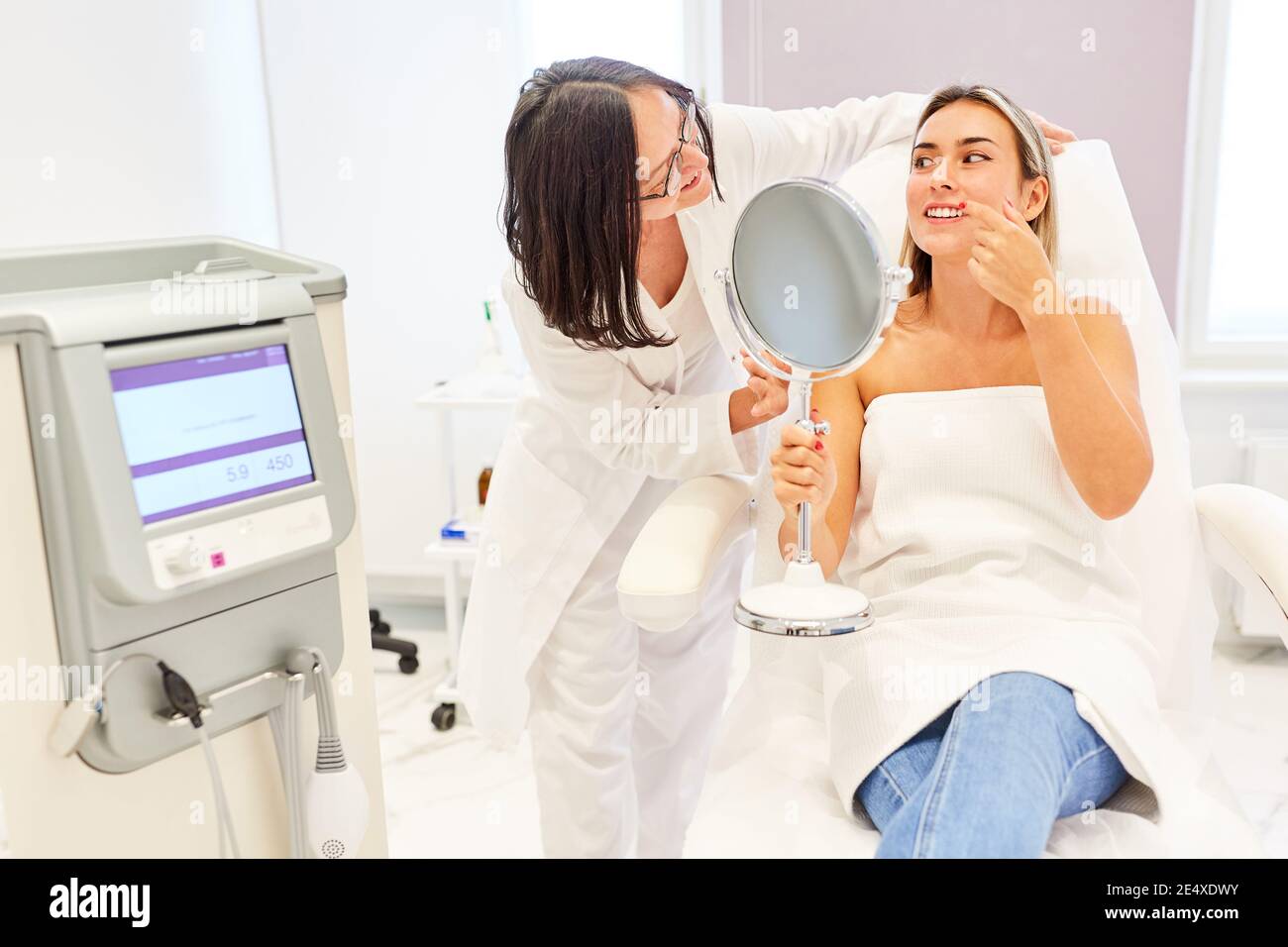 Patient et médecin donnant des conseils avant le traitement ou le facilift dedans la pratique du dermatologue Banque D'Images