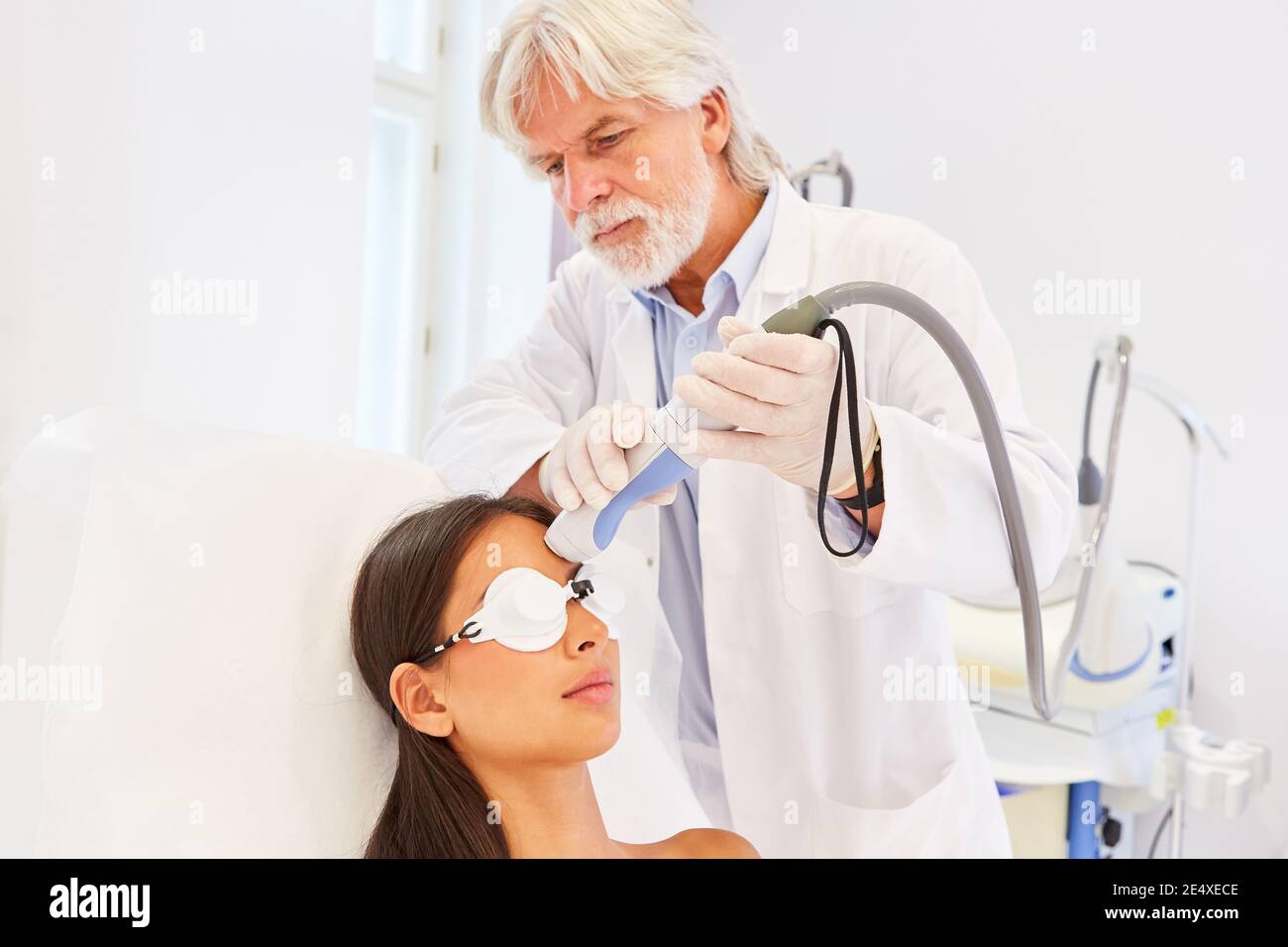 Chirurgien esthétique spécialisé dans le traitement au laser sur le front d'un patient Banque D'Images