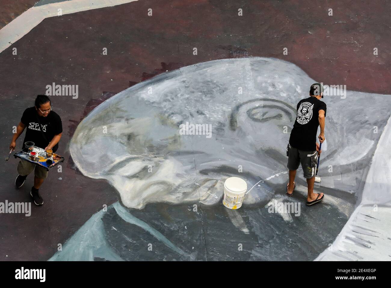Manille. 25 janvier 2021. Des artistes peignent une murale géante sur le sol d'un terrain de basket-ball en l'honneur de la légende du basket-ball Kobe Bryant et de sa fille Gianna à Manille, aux Philippines, le 25 janvier 2021. Le groupe Tenement Visual Artists a fait la fresque un jour avant le 1er anniversaire de la mort de Kobe Bryant et Gianna, qui sont morts dans un accident d'hélicoptère avec sept autres à Calabasas, dans le sud de la Californie l'année dernière. Crédit: Rouelle Umali/Xinhua/Alamy Live News Banque D'Images