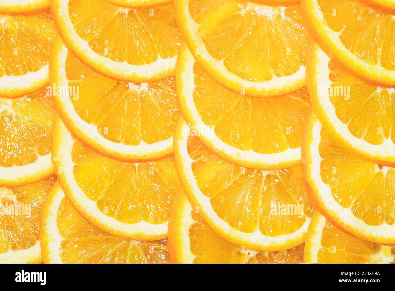 Tranches de citron orange sur fond jaune. Une coupe orange en tranches est située sur la table. Banque D'Images