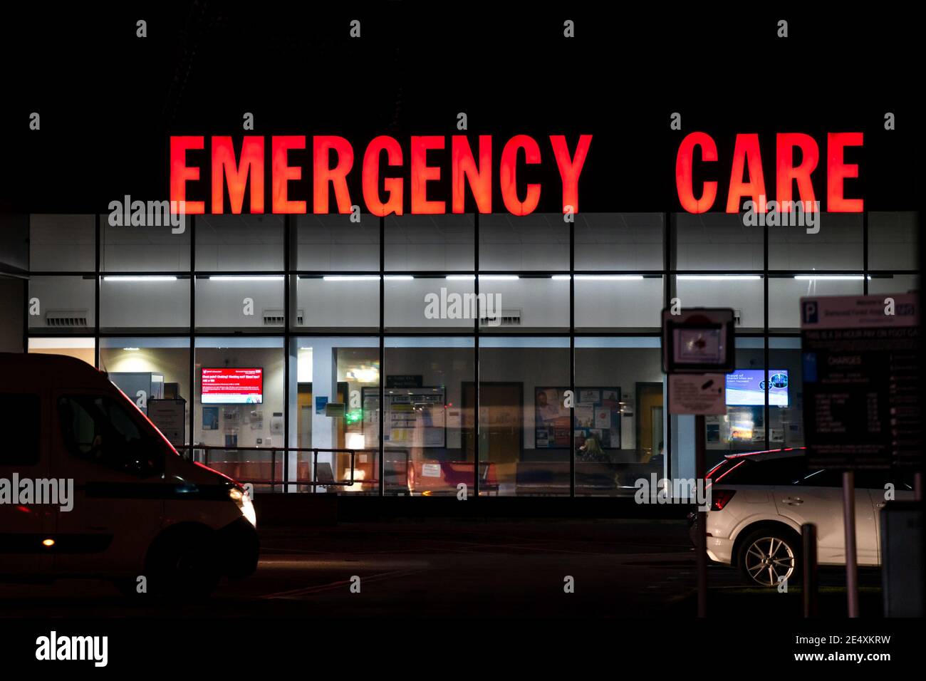 Verre avant nuit allumé bleu vert rose image miroir Urgence accident de service de soins NHS rouge éclairé de nuit médical d'urgence Centre A&E Banque D'Images