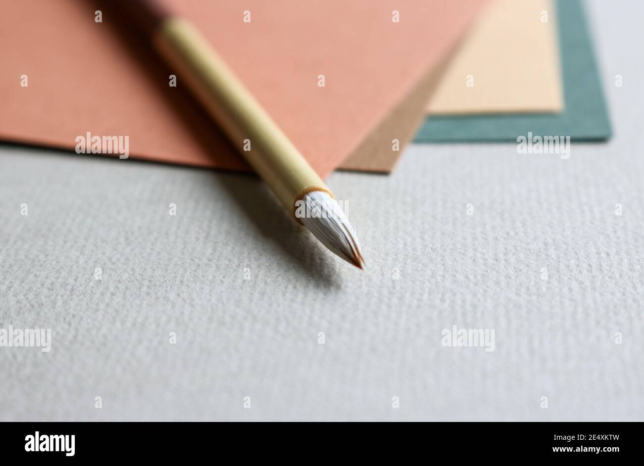 Gros plan de papier beaux-arts de couleur verte, une enveloppe verte avec un sceau doré et une brosse de calligraphie en bois posée dessus Banque D'Images