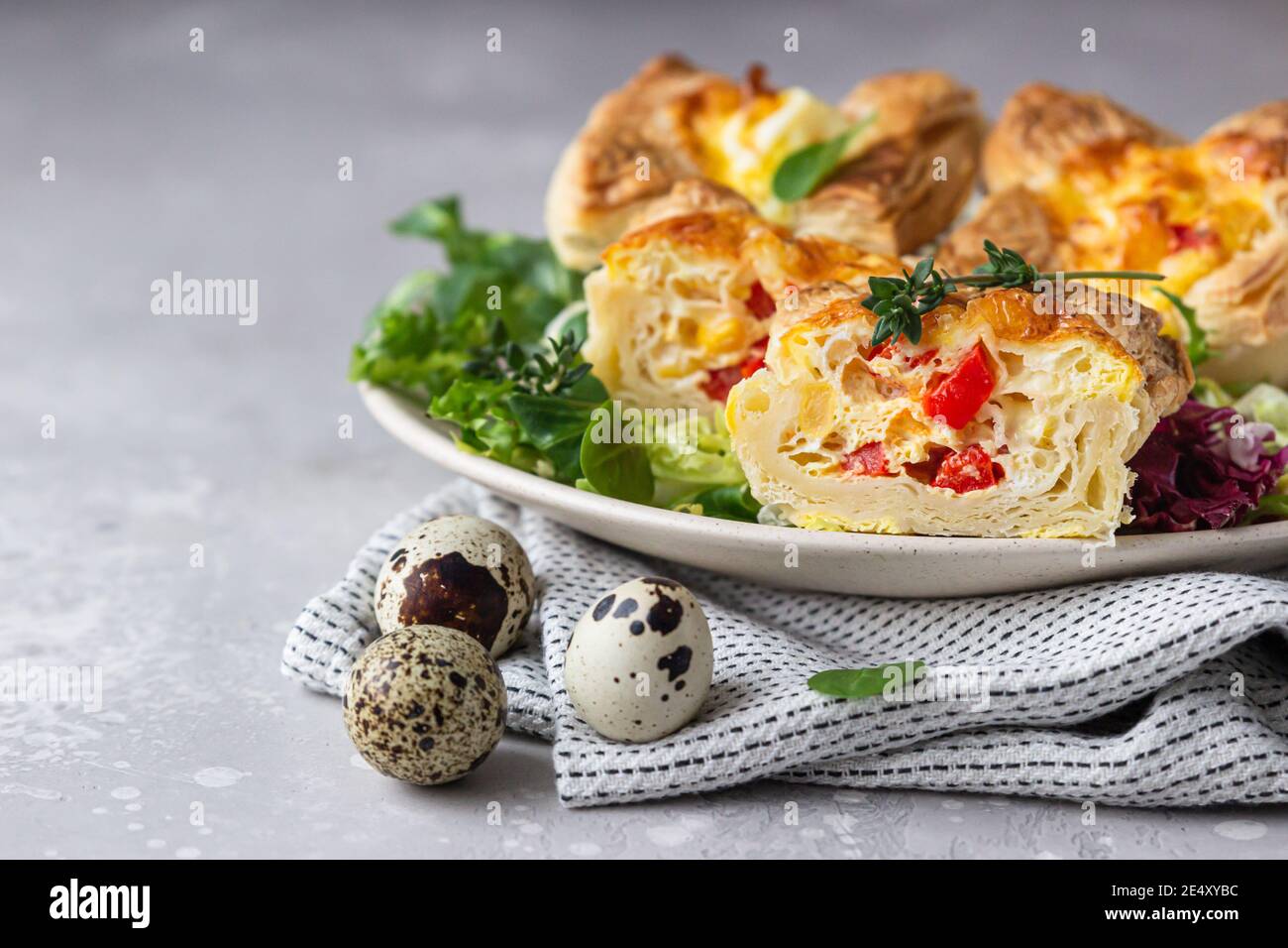 Mini quiche, tarte ou tarte avec légumes servis sur une assiette avec salade verte. Mise au point sélective. Banque D'Images
